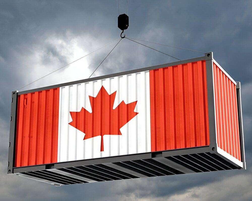 Canadian flag shipping container lifted by a crane against a cloudy sky